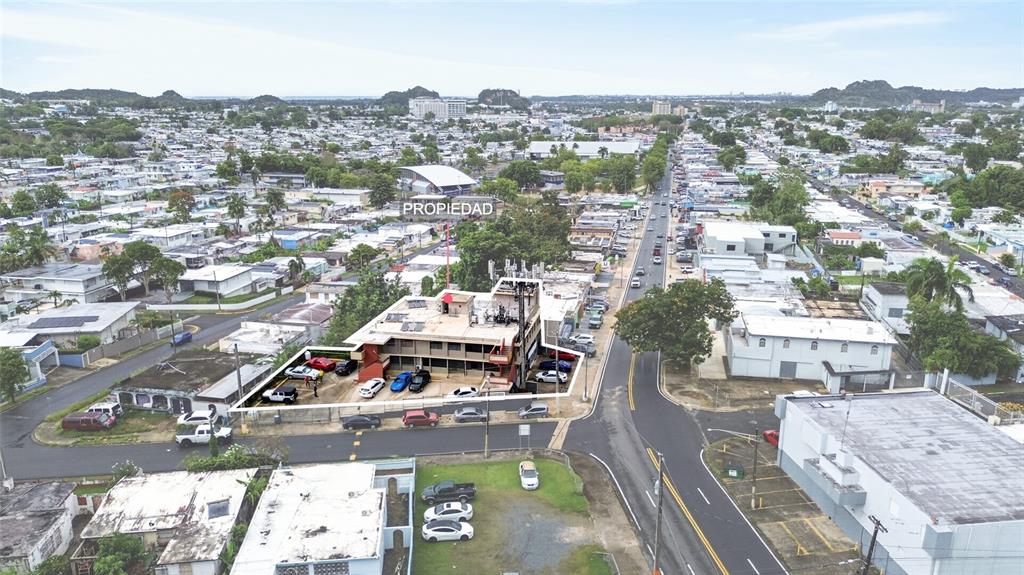 An aerial view shows a multi-story commercial building with a parking lot in a neighborhood — 1 HNAS DAVILA, BETANCES ESQ A D, BAYAMON, PR