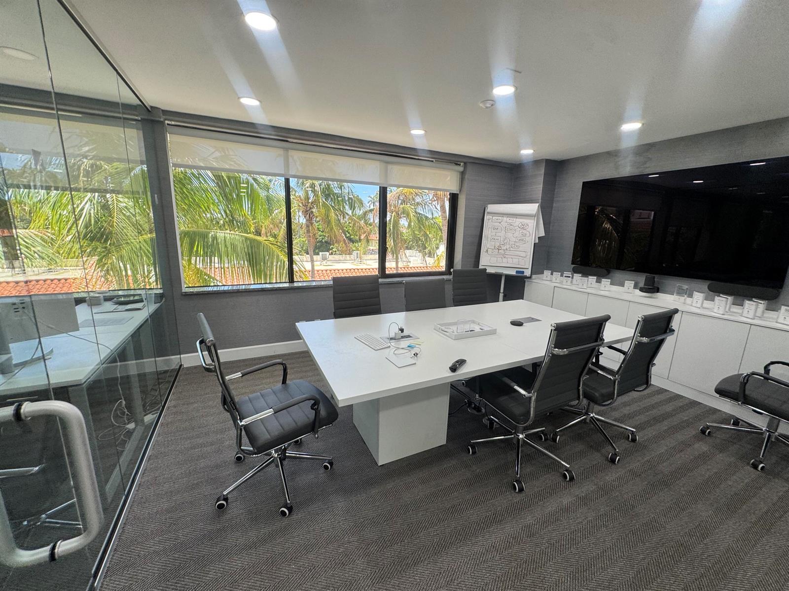 A modern conference room features a white table, black office chairs, and a large television — 201 Worth Avenue # 301, Palm Beach FL 33480, PALM BEACH, FL