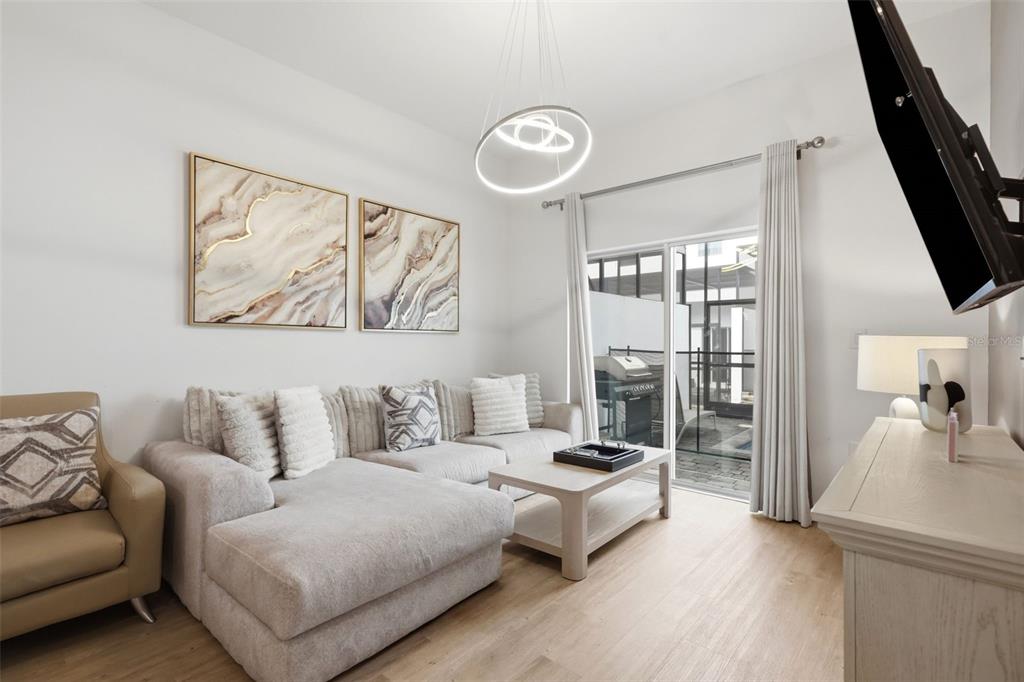 A living room features a sectional sofa, a coffee table, wall art, and a sliding door — 285 FAMAGUSTA DRIVE, DAVENPORT, FL