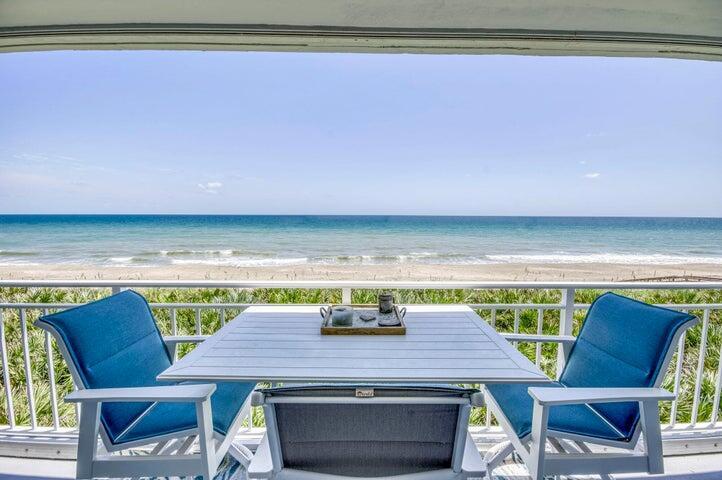 A balcony with a white table and three blue chairs overlooking the ocean — 9600 S Ocean Drive # 306, Jensen Beach FL 34957, JENSEN BEACH, FL