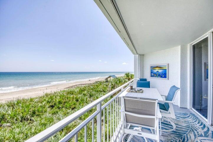 A balcony with outdoor furniture overlooks a sandy beach and the ocean — 9600 S Ocean Drive # 306, Jensen Beach FL 34957, JENSEN BEACH, FL