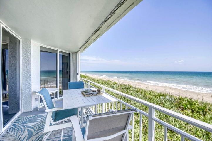 A balcony with a dining set overlooks a sandy beach and the ocean — 9600 S Ocean Drive # 306, Jensen Beach FL 34957, JENSEN BEACH, FL