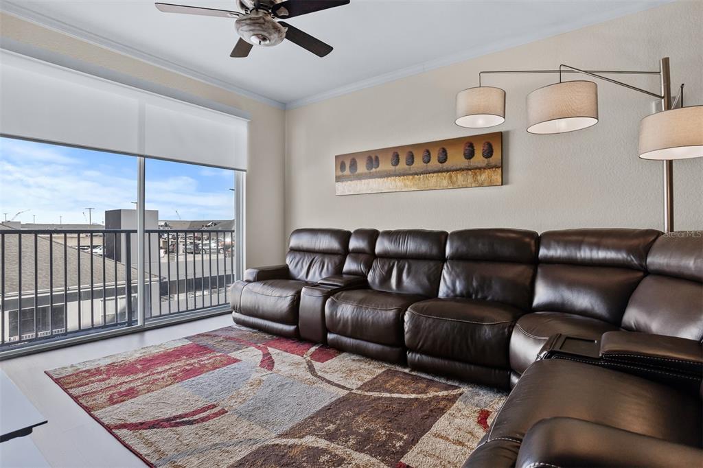 A living room features a brown leather sectional, a patterned rug, and a sliding glass door — 700 S HARBOUR ISLAND BOULEVARD UNIT 532, TAMPA, FL