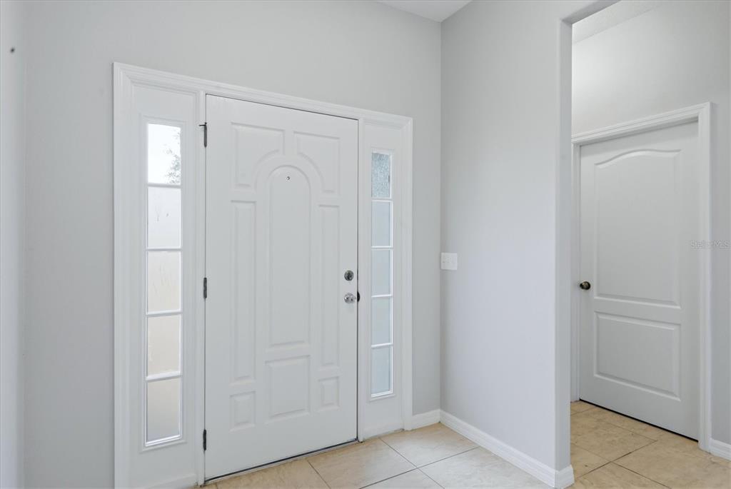 An entryway features a white front door with sidelights and tile flooring — 12218 LAVENDER LOOP, BRADENTON, FL