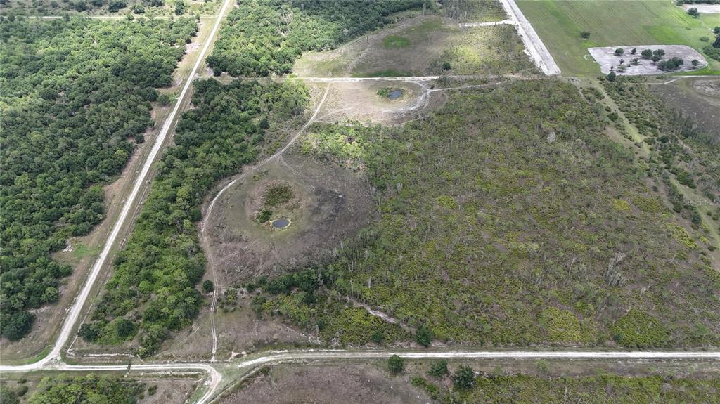 An aerial view shows a large, undeveloped plot of land with trees and two small ponds — 21061 GRANVILLE ROAD, NORTH FORT MYERS, FL