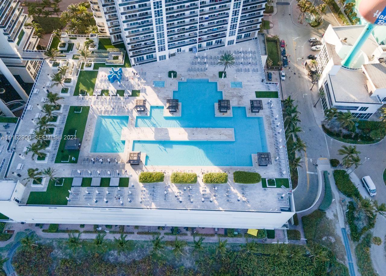 An aerial view shows a large multi-level swimming pool deck at a high-rise building — 1830 OCEAN DR # 4710, Hallandale Beach FL 33009, HALLANDALE BEACH, FL