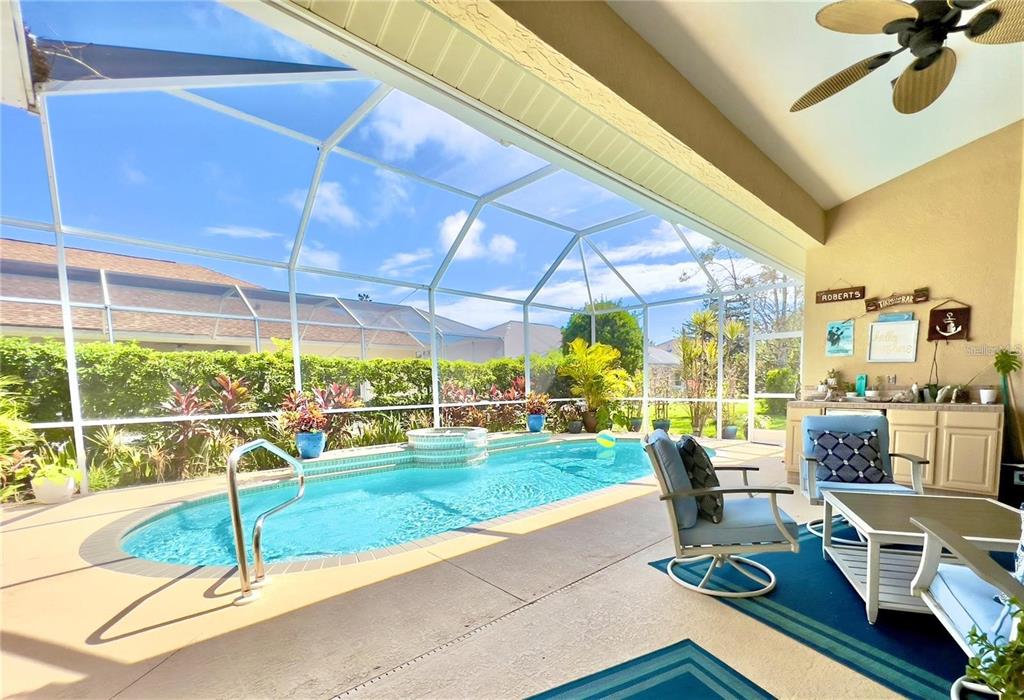 A covered patio features a swimming pool with a spa enclosure and outdoor seating — 5831 CLEVELAND ROAD, VENICE, FL