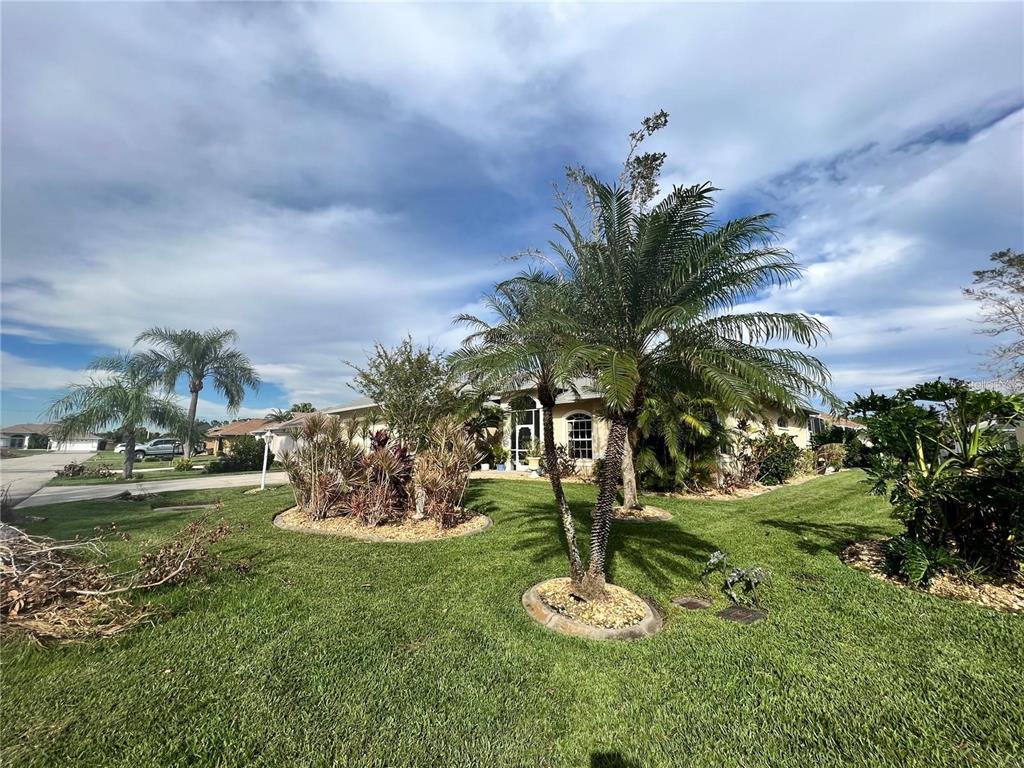 A single-story house with a landscaped front yard, palm trees, and a paved driveway — 5831 CLEVELAND ROAD, VENICE, FL