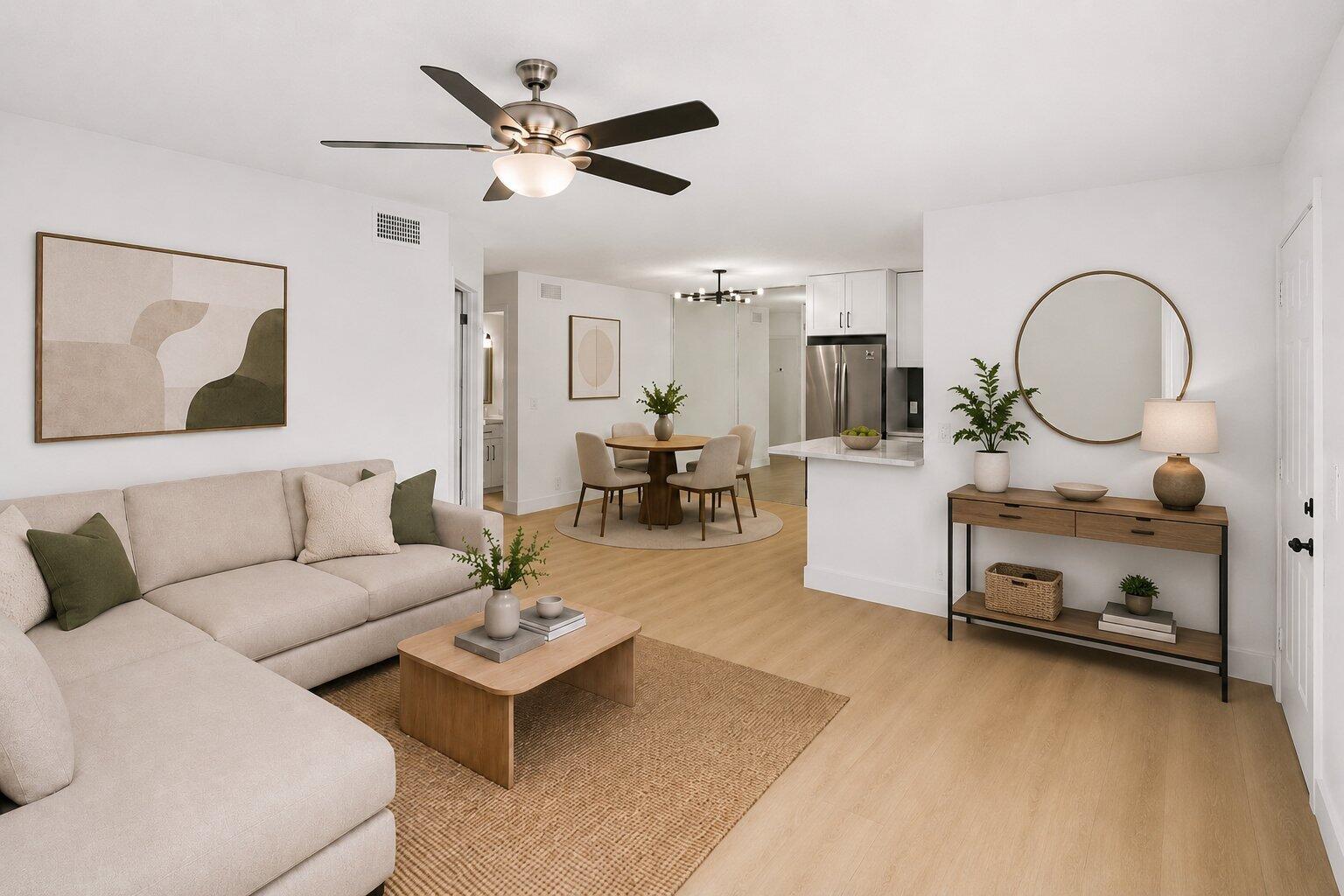 An open-concept living and dining area features light wood flooring, neutral furniture, and a kitchen — 588 Trace Circle # 102, Deerfield Beach FL 33441, DEERFIELD BEACH, FL