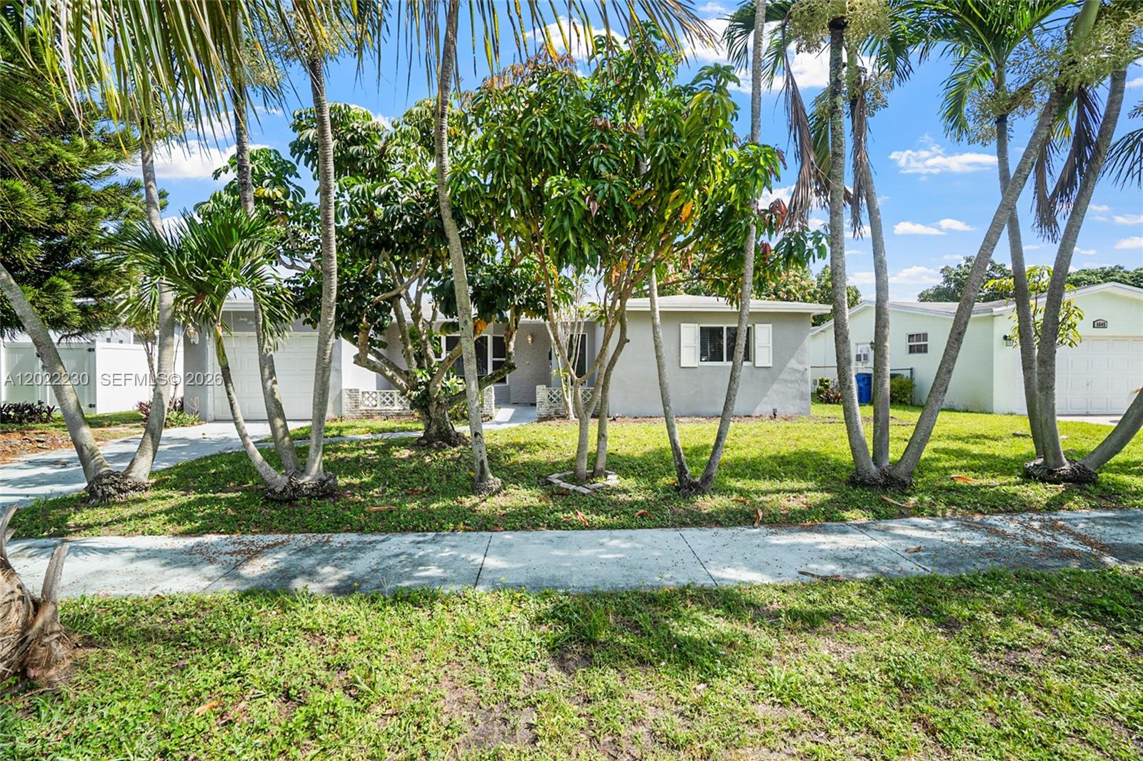 A single-story gray house with a front lawn and several palm trees — 6667 NW 1st St, Margate FL 33063, MARGATE, FL