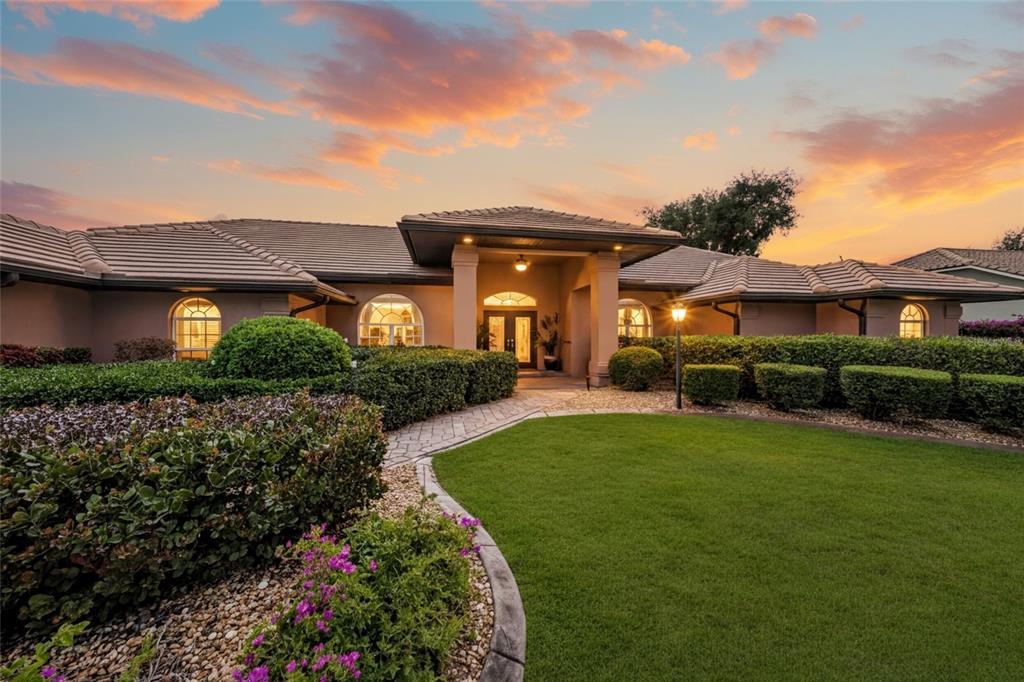 A single-story house with a tiled roof and arched windows sits behind a manicured lawn — 8838 WILD DUNES DRIVE, SARASOTA, FL