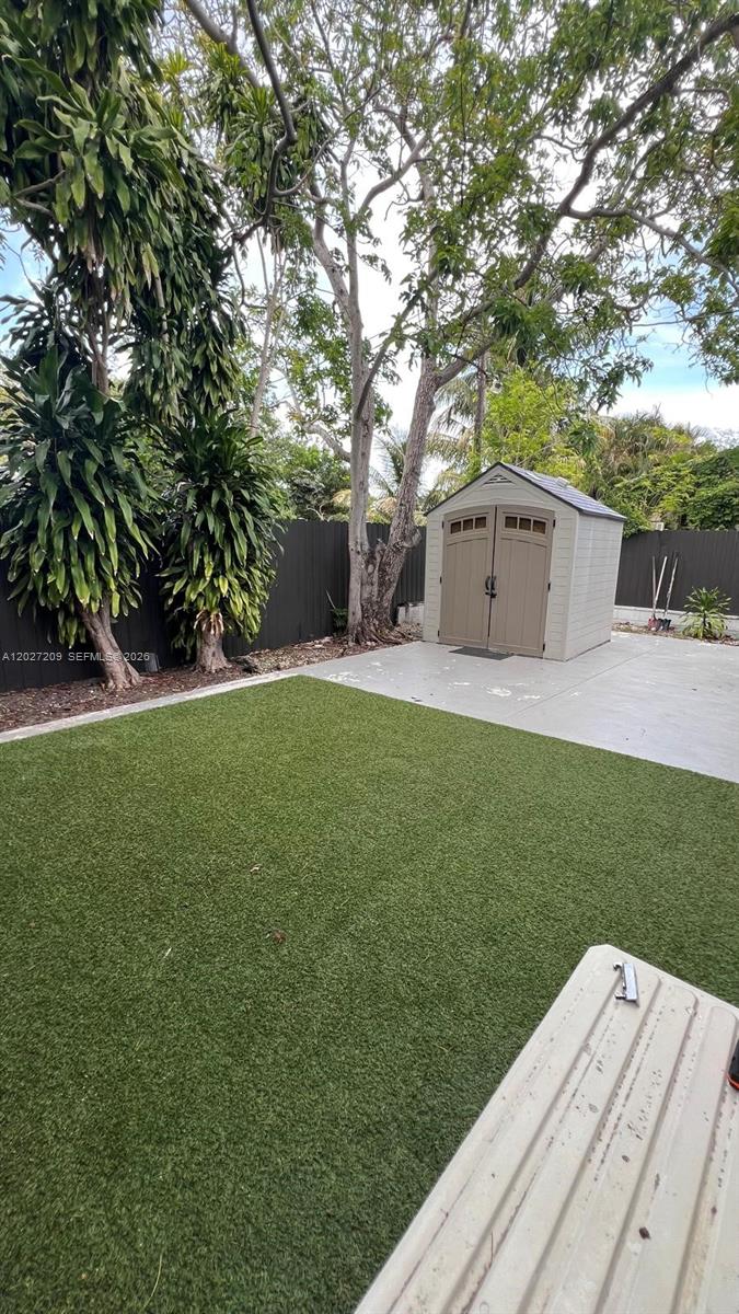 A backyard features a patch of artificial turf, a concrete patio, and a storage shed — 841 S 24th Ave # B, Hollywood FL 33020, HOLLYWOOD, FL