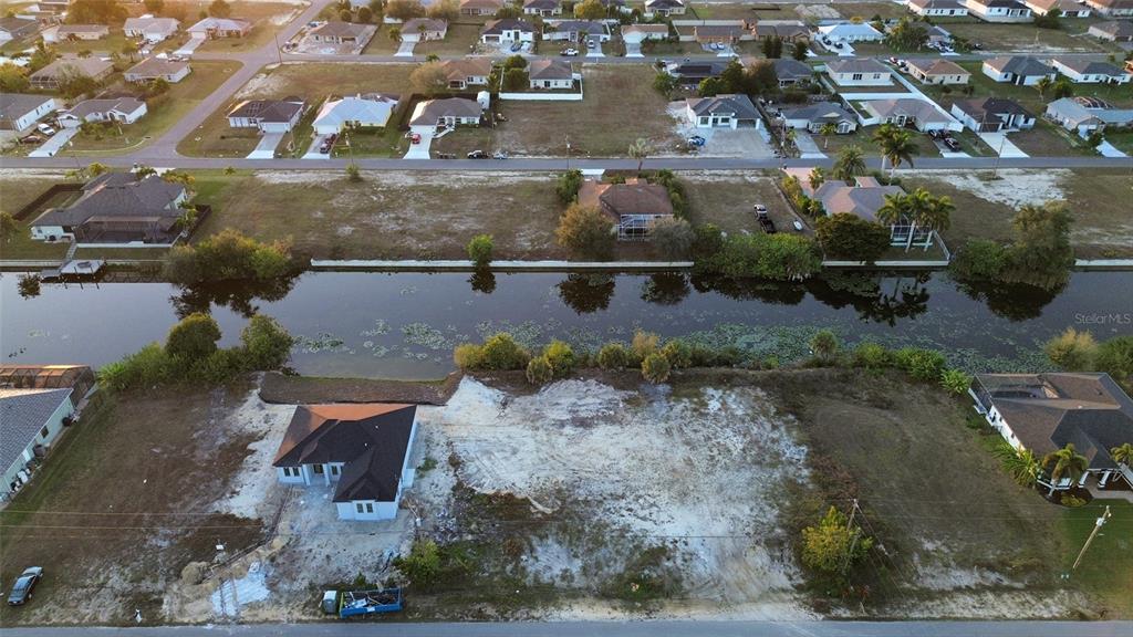 An aerial view shows a house under construction on a waterfront lot with canal access — 1314 NE 6TH AVENUE, CAPE CORAL, FL