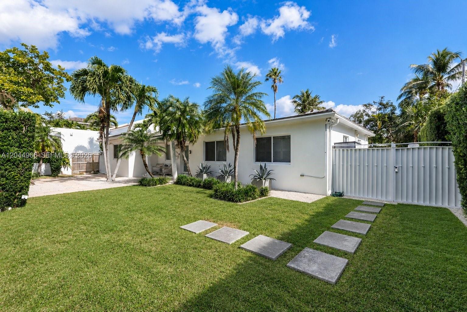 A white single-story house features a green lawn, palm trees, and a stone walkway — 301 Hampton Ln, Key Biscayne FL 33149, KEY BISCAYNE, FL
