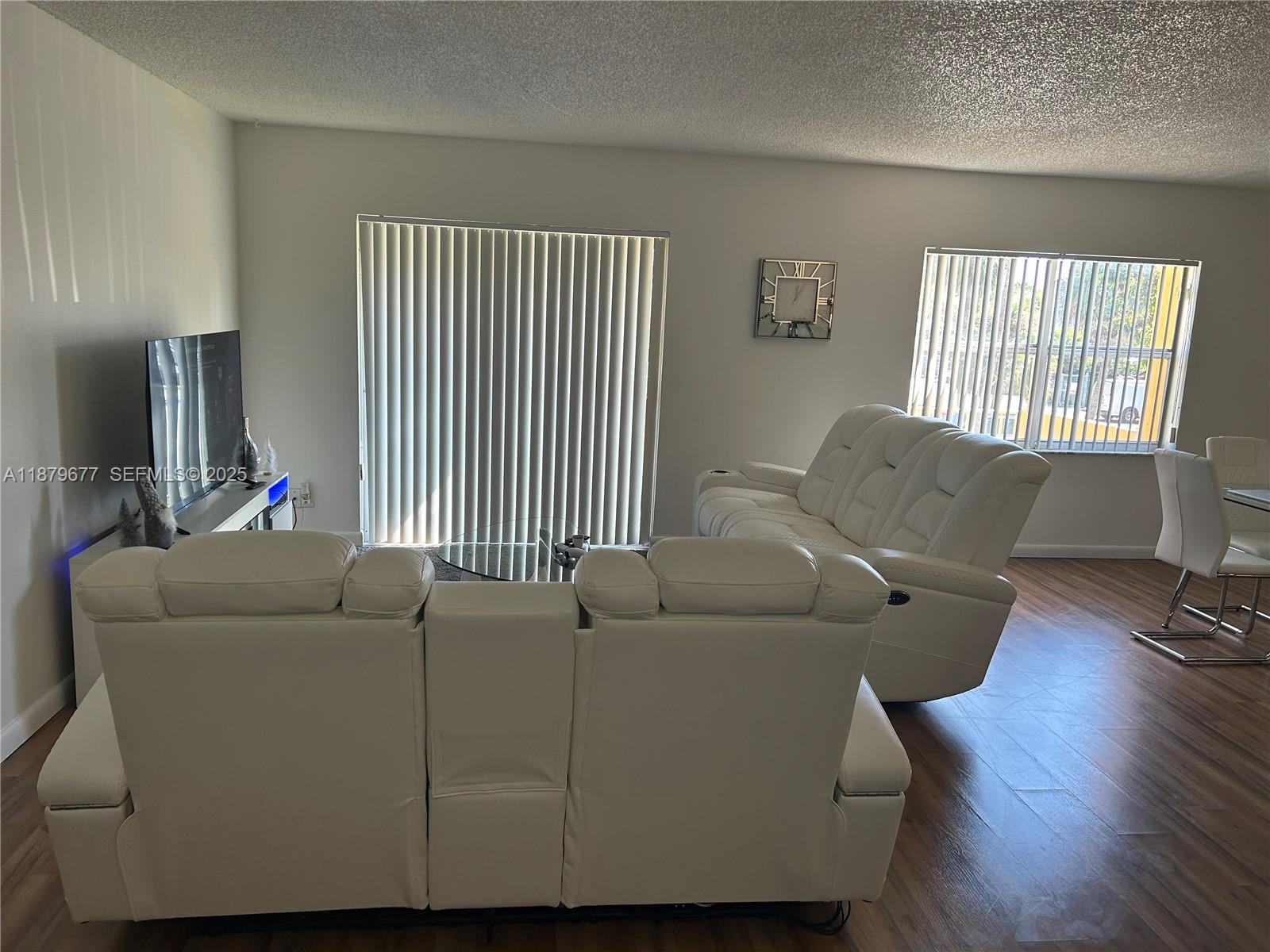 A living room features white leather sofas, a glass coffee table, and wood-look flooring — 17901 NW 68th Ave # R209, Hialeah FL 33015, HIALEAH, FL