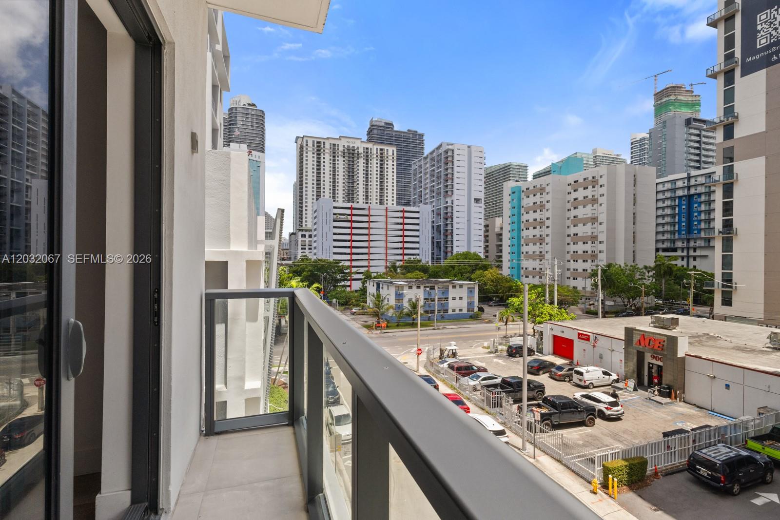 A balcony overlooks a city street with an Ace Hardware store and surrounding high-rise buildings — 239 SW 9TH St # 301, Miami FL 33130, MIAMI, FL
