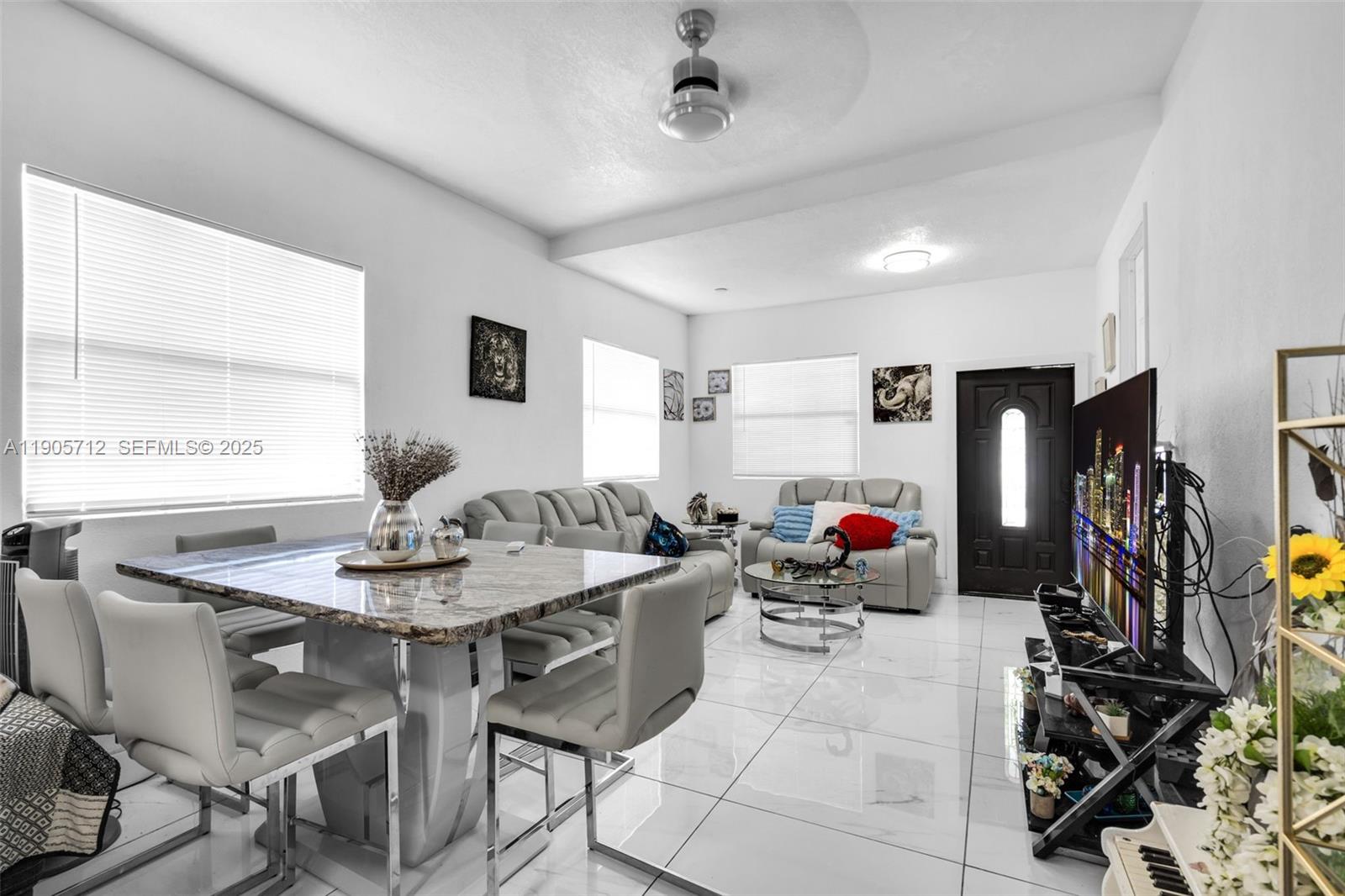 A living and dining room with white tile floors, grey furniture, and a marble table — 3166 NW 102nd St, Miami FL 33147, MIAMI, FL