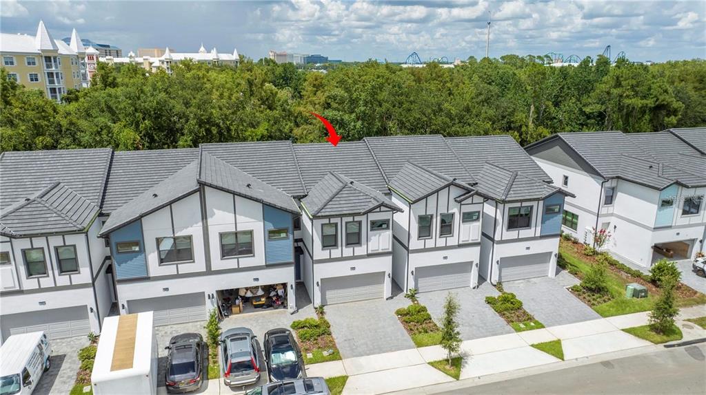 An aerial view of a row of modern townhouses with gray tile roofs and driveways — 10443 EBB TIDE LANE, ORLANDO, FL