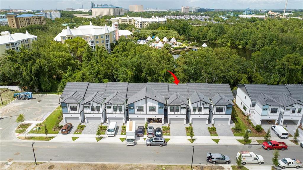 An aerial view shows a row of modern townhouses with gray roofs and paved driveways — 10443 EBB TIDE LANE, ORLANDO, FL