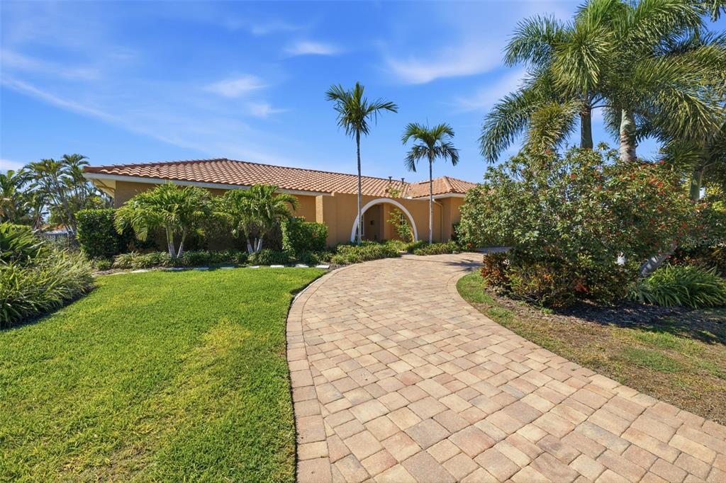 A paved driveway leads to the entrance of a single-story house with a tiled roof — 1997 HAWAII AVENUE NE, ST PETERSBURG, FL