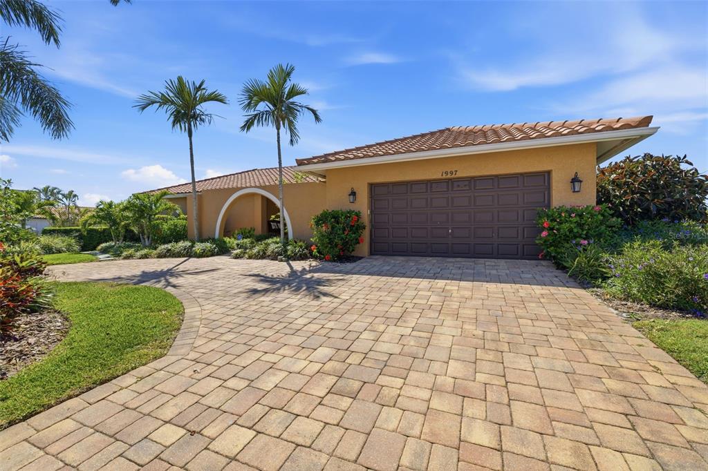 A single-story house with a brown garage door, tiled roof, and a paved driveway — 1997 HAWAII AVENUE NE, ST PETERSBURG, FL