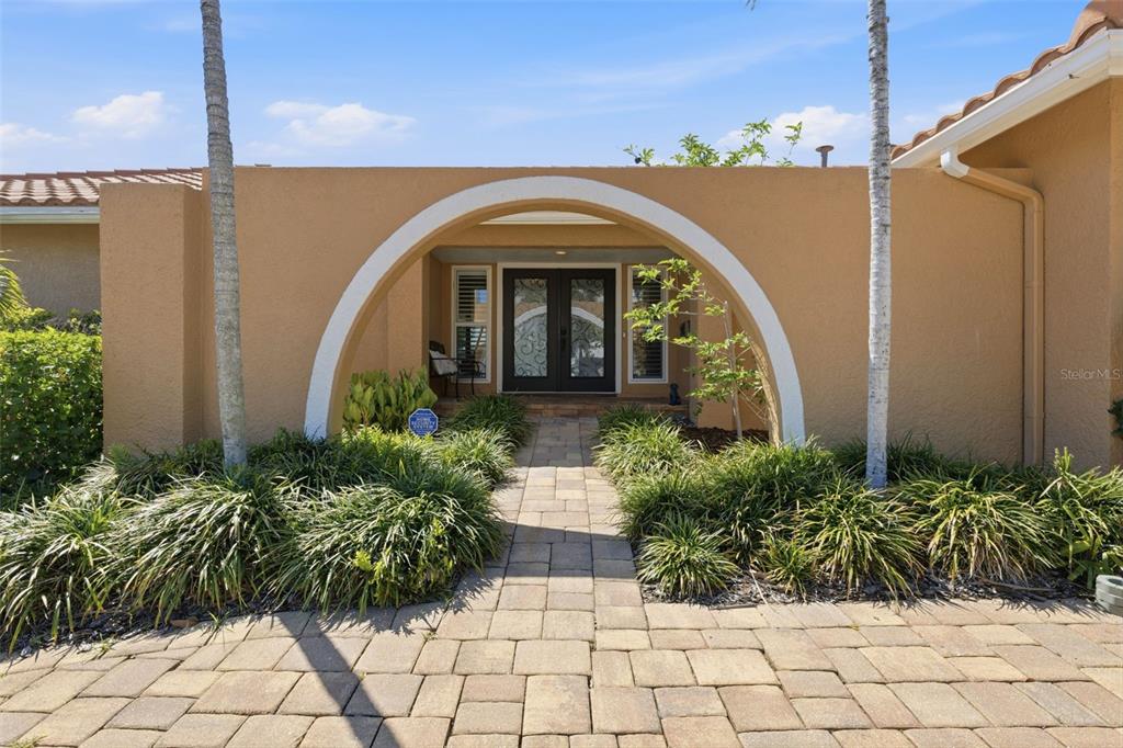 A paved walkway leads to a front entrance framed by a large white archway — 1997 HAWAII AVENUE NE, ST PETERSBURG, FL