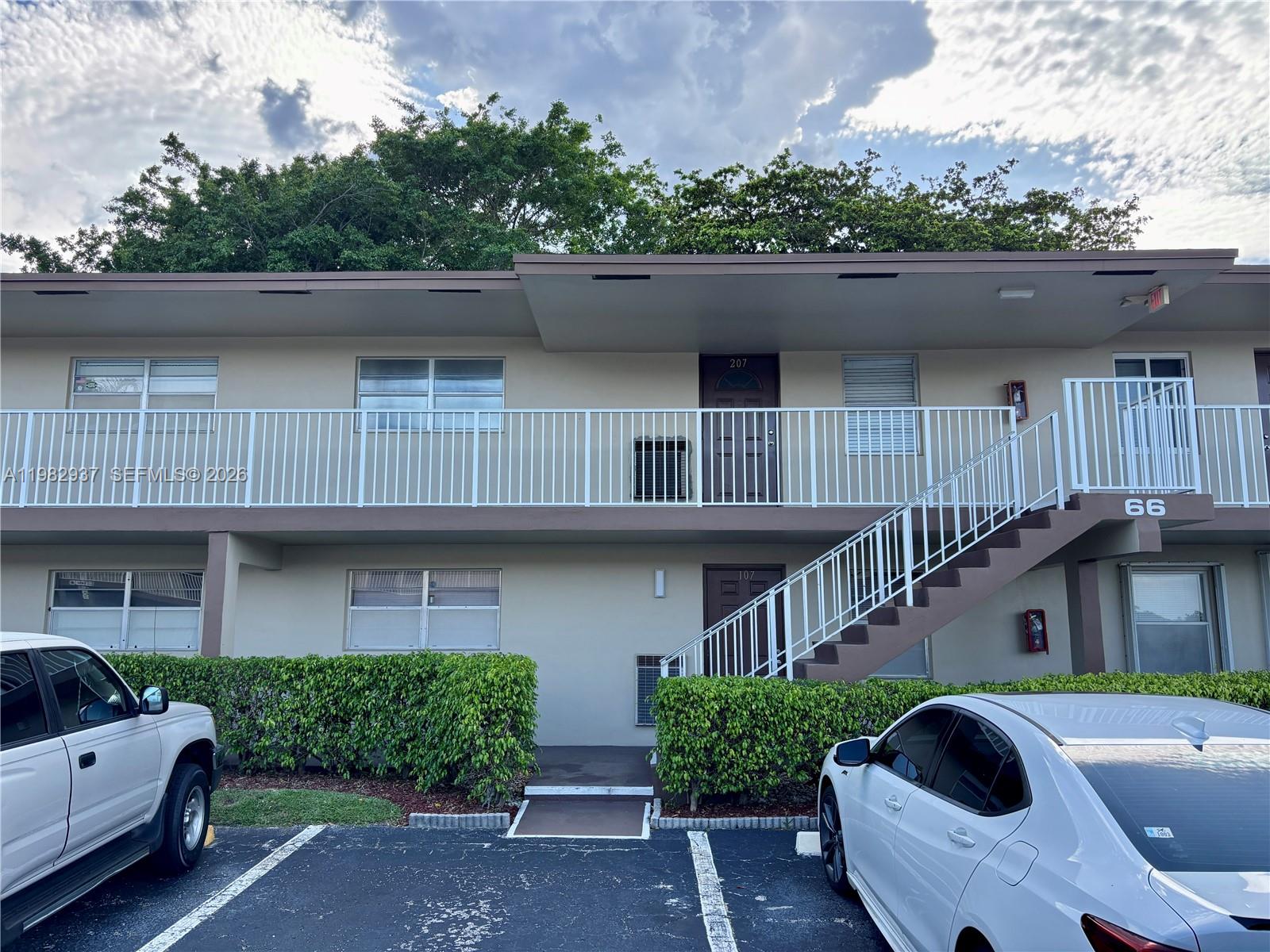 A two-story apartment building exterior features a white metal staircase and balcony railings — 601 NW 80th Ave # 207, Margate FL 33063, MARGATE, FL