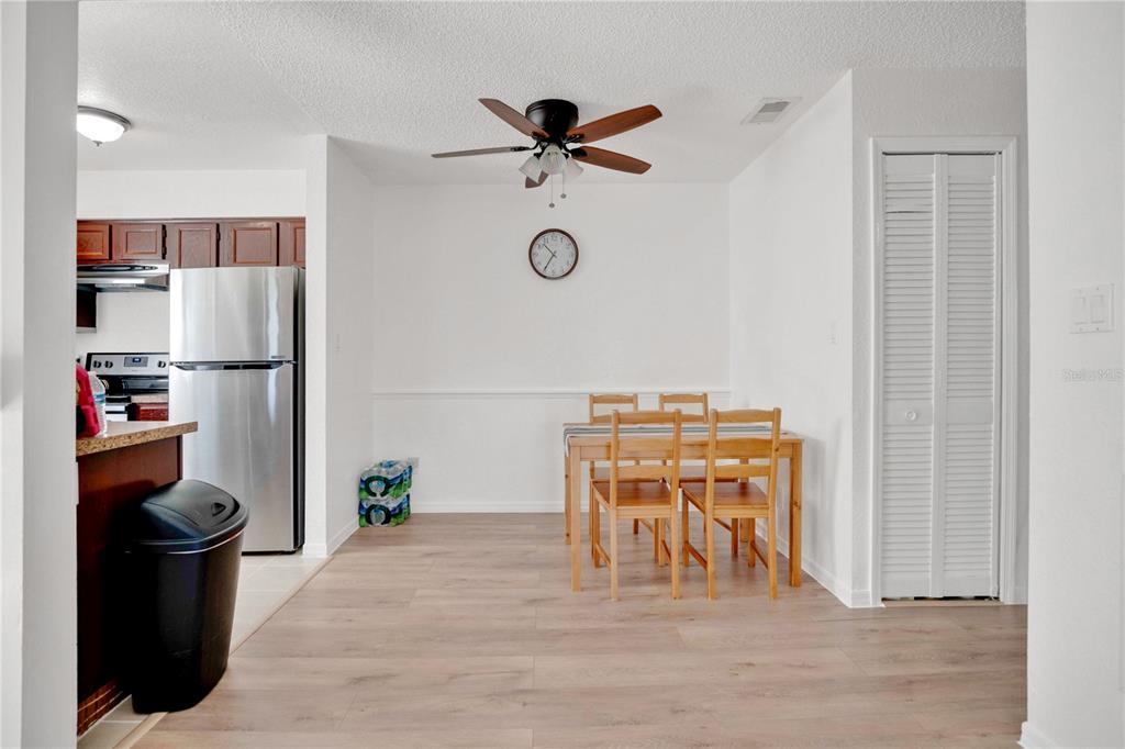 A dining area with light wood flooring, a wooden table, and a ceiling fan — 2923 ANTIQUE OAKS CIRCLE UNIT 34, WINTER PARK, FL