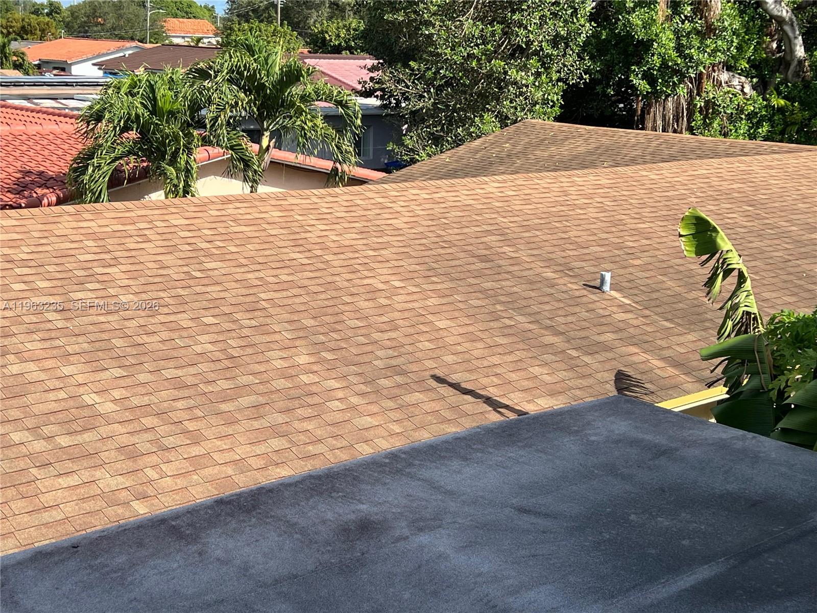 An elevated view shows a brown shingled roof next to a flat gray roof — 733 NW 33rd Ave, Miami FL 33125, MIAMI, FL