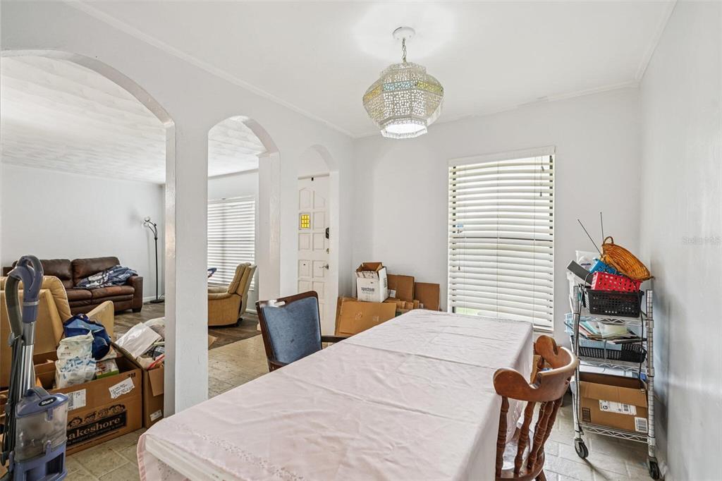 A dining room features arched doorways, a white pendant light, and a table with chairs — 15019 NW 134TH TERRACE, ALACHUA, FL