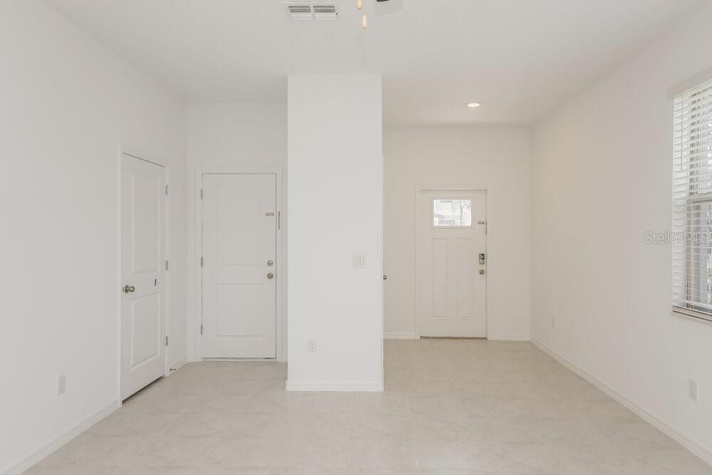An interior view showing a white-walled entryway with tile flooring and two white doors — 2136 AZURE VIEW WAY, LUTZ, FL