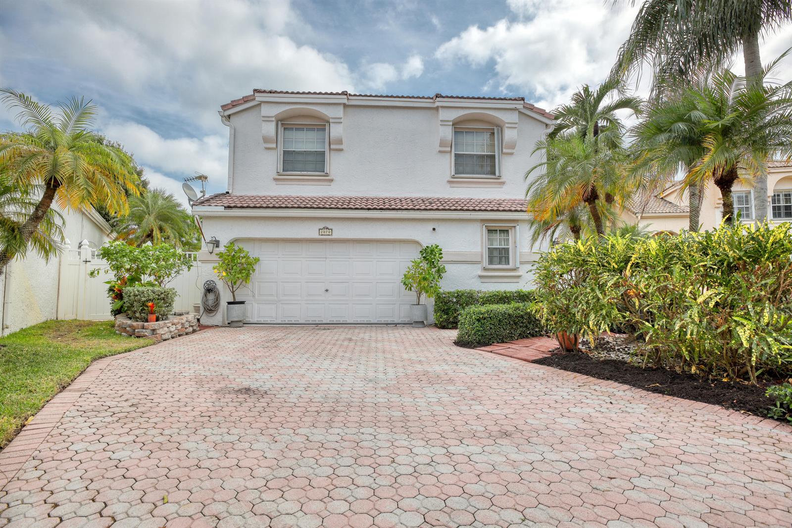 A two-story house with a white stucco facade, a two-car garage, and a paved driveway — 2070 Chagall Circle, West Palm Beach FL 33409, WEST PALM BEACH, FL