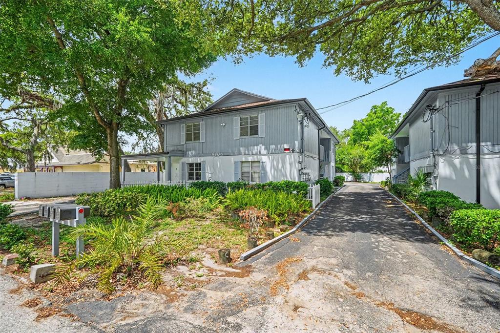A two-story gray apartment building with a paved driveway and surrounding trees — 9208 N CONNECHUSETT ROAD UNIT C, TAMPA, FL
