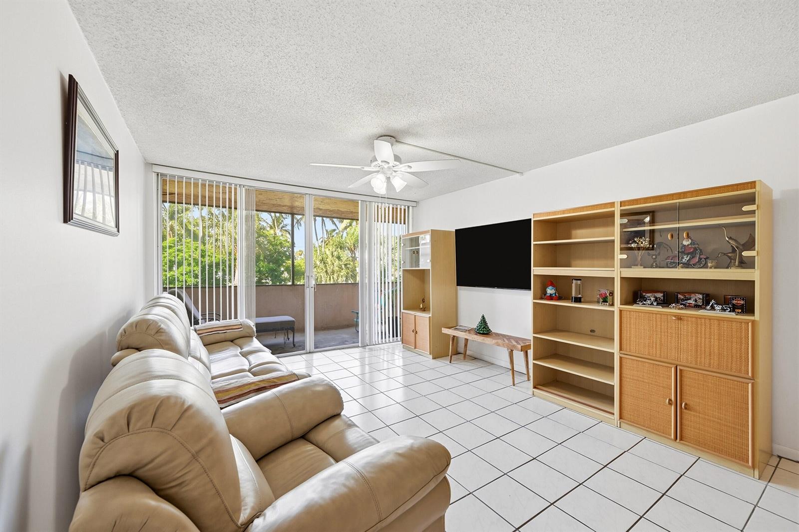 A living room features white tile floors, a beige leather sofa, and large sliding glass doors — 740 S Federal Highway # 208, Pompano Beach FL 33062, POMPANO BEACH, FL