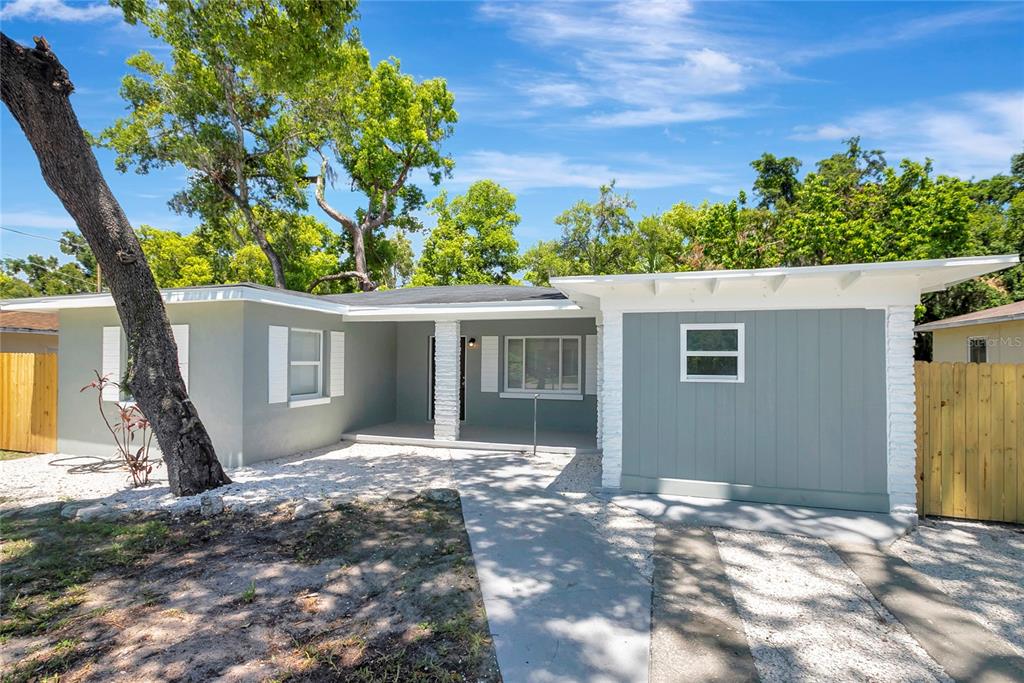 A single-story house with gray siding, white trim, and a covered front porch — 6105 N 23RD STREET, TAMPA, FL