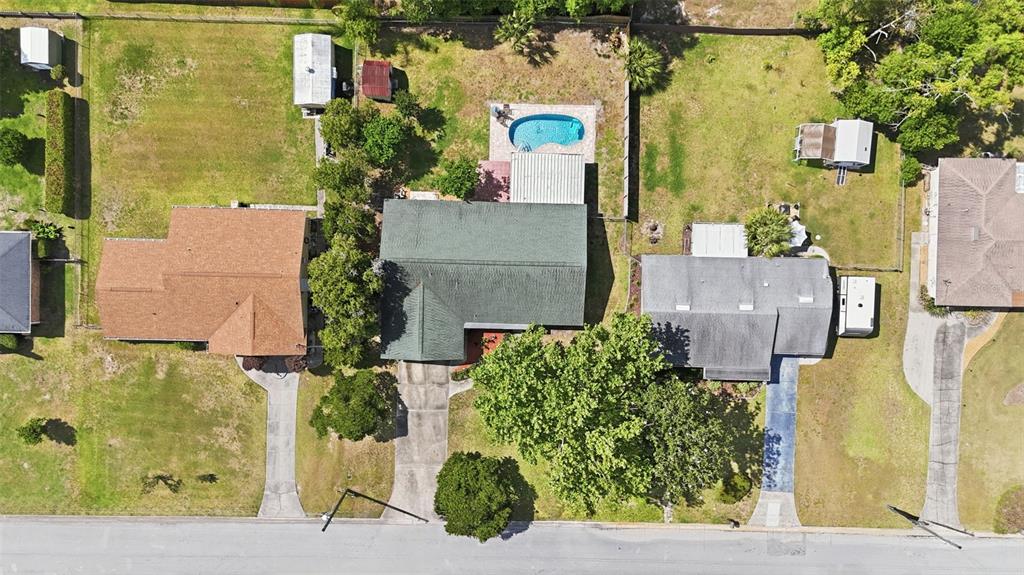 An aerial view shows three suburban houses with driveways, backyards, and a swimming pool — 3996 LAKE ELEANOR DR, MOUNT DORA, FL