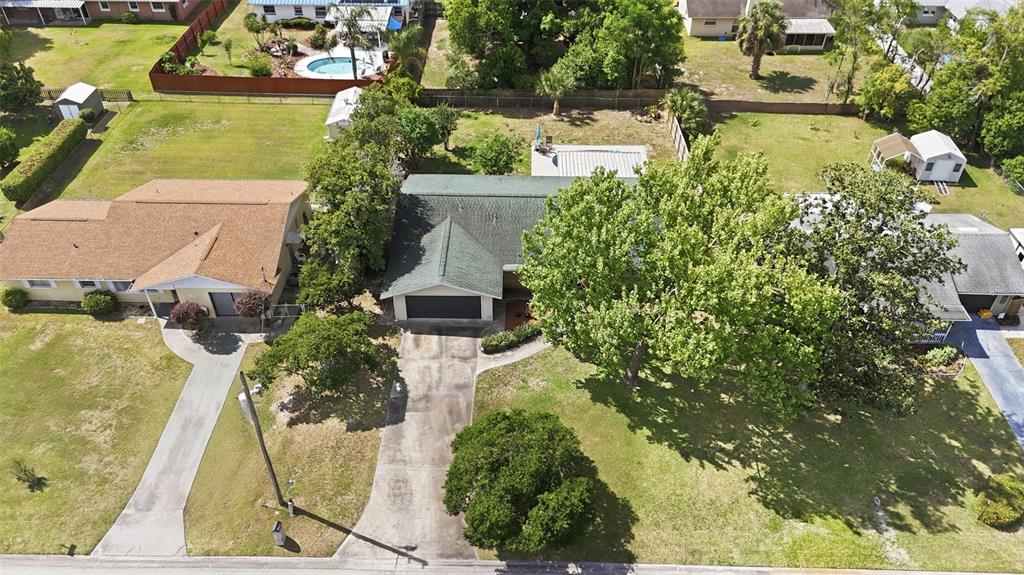An unfinished garage with exposed plywood walls, a concrete floor, and two exterior doors — 3996 LAKE ELEANOR DR, MOUNT DORA, FL