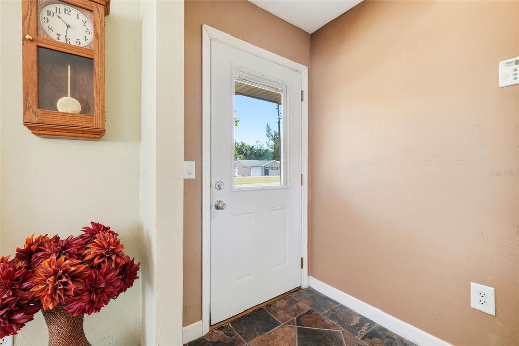 A garage with a concrete floor, white walls, two exterior doors, and metal shelving units — 3996 LAKE ELEANOR DR, MOUNT DORA, FL