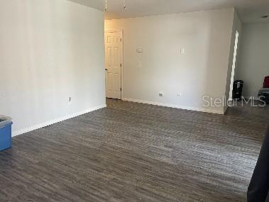 An empty room features light gray walls and wood-look laminate flooring — 7210 N MANHATTAN AVENUE UNIT 621, TAMPA, FL