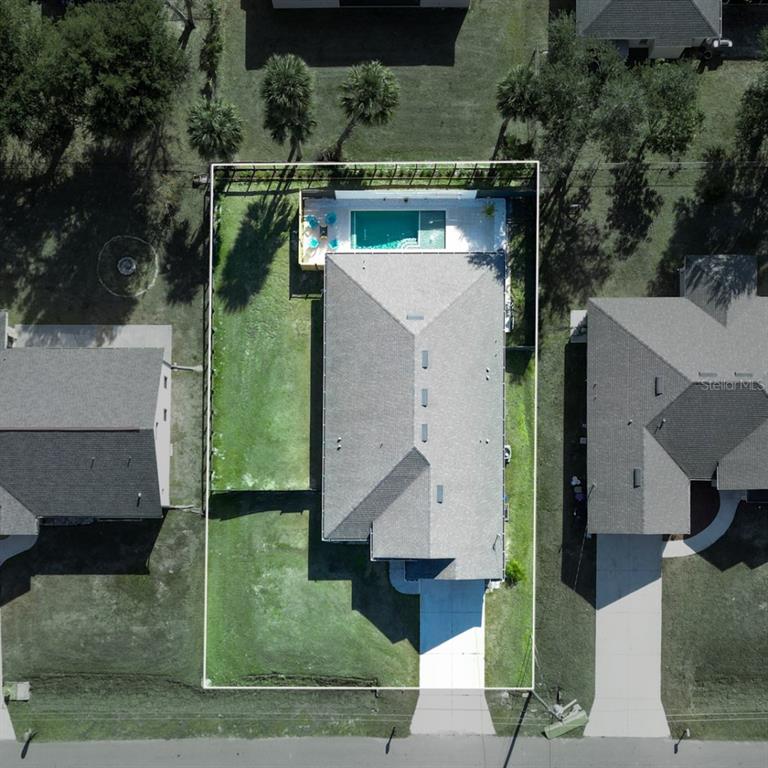 An aerial view shows a house with a swimming pool and a fenced backyard — 4638 CLARKE STREET, NORTH PORT, FL