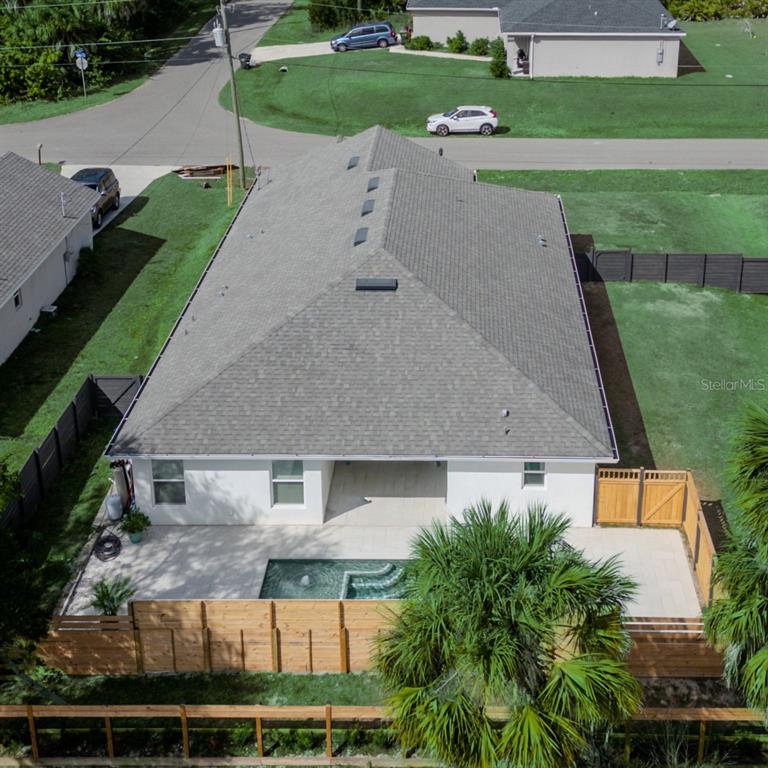An aerial view shows the back of a house with a pool and wooden fencing — 4638 CLARKE STREET, NORTH PORT, FL
