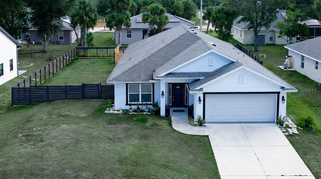 An aerial view of a single-story house with a white exterior, gray roof, and fenced yard — 4638 CLARKE STREET, NORTH PORT, FL