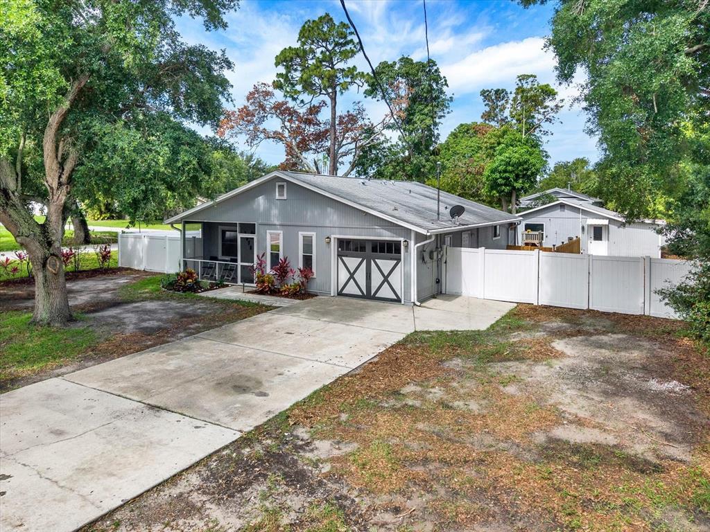 A single-story house with gray vertical siding, a screened porch, and a garage — 1978 DIX STREET, LARGO, FL