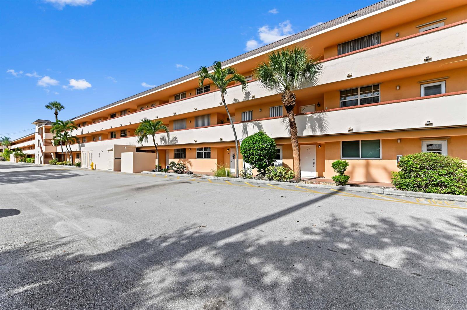 A multi-story apartment building with peach-colored exterior walls and palm trees in the parking lot — 4500 N Federal Highway # 147f, Lighthouse Point FL 33064, LIGHTHOUSE POINT, FL