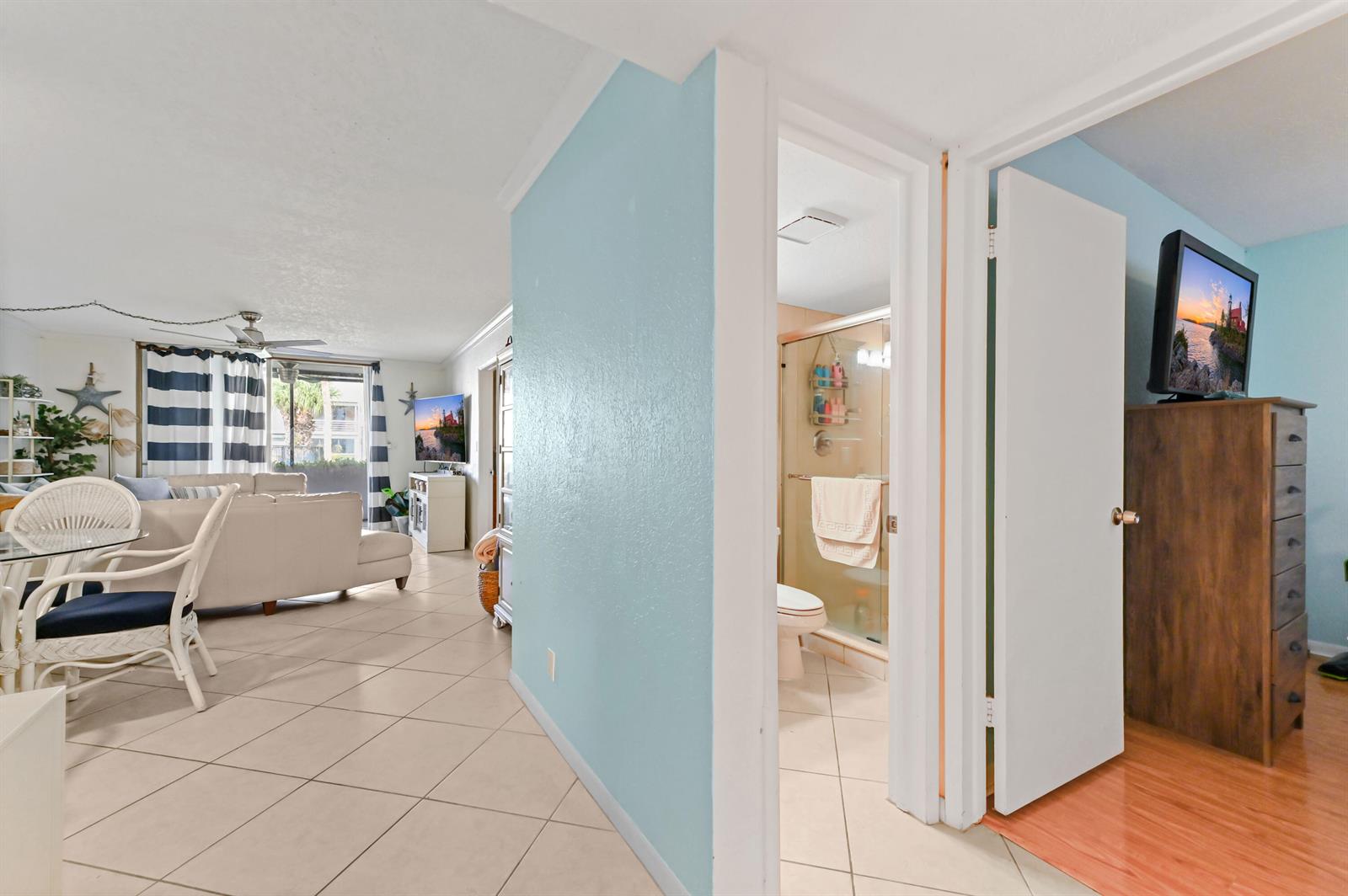 A view from a tiled hallway into a living area and a small bathroom — 4500 N Federal Highway # 147f, Lighthouse Point FL 33064, LIGHTHOUSE POINT, FL