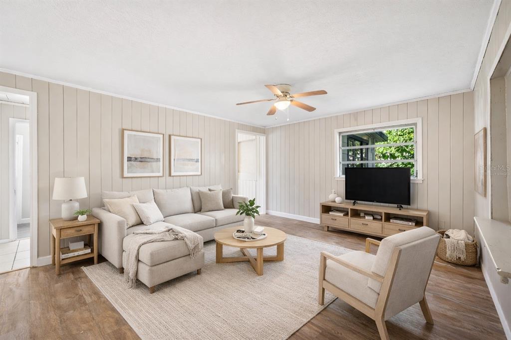 A living room features light wood paneling, a sectional sofa, a coffee table, and television — 3221 & 3225 CRUTCHFIELD ROAD, LAKELAND, FL
