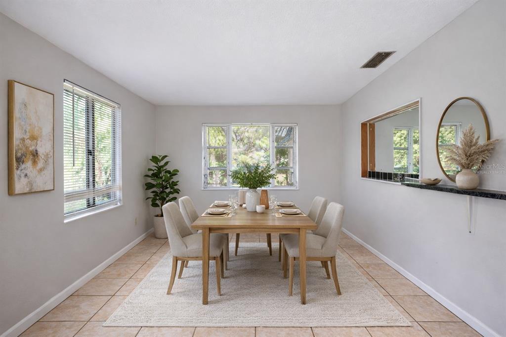A dining room features a wooden table with six chairs, a rug, and two windows — 3221 & 3225 CRUTCHFIELD ROAD, LAKELAND, FL