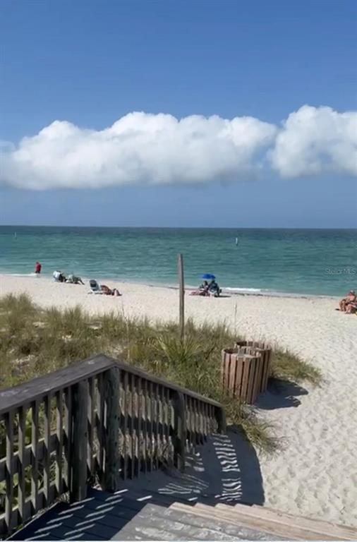 A wooden staircase leads down to a sandy beach with people and ocean views — 2210 BUSHER STREET, PORT CHARLOTTE, FL