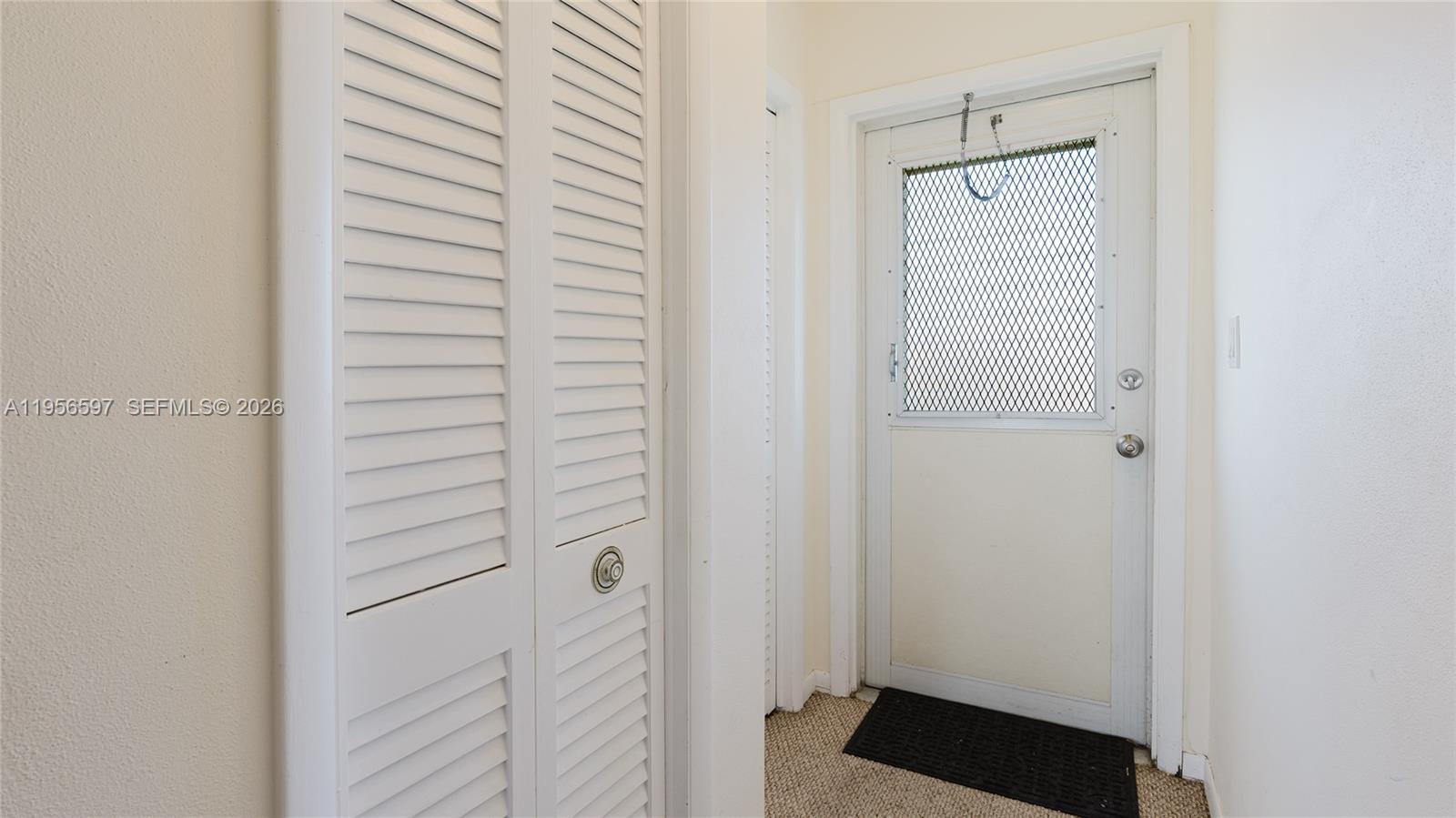 A white louvered closet door stands next to a white exterior door with a screen — 301 S Golf Blvd # 172, Pompano Beach FL 33064, POMPANO BEACH, FL