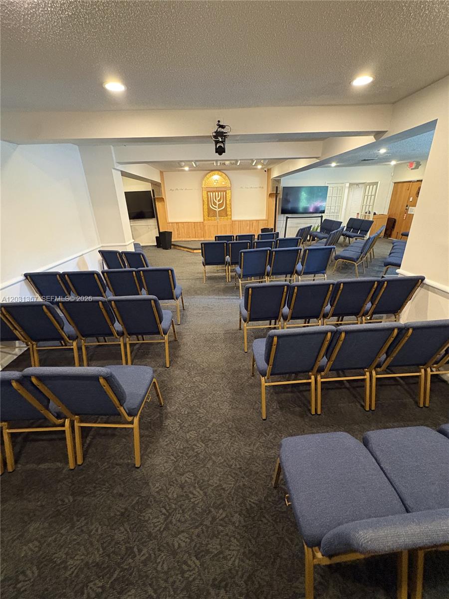 This room features rows of blue chairs facing a wooden ark with a menorah design — 11715 SW 87th Ave, Miami FL 33176, MIAMI, FL